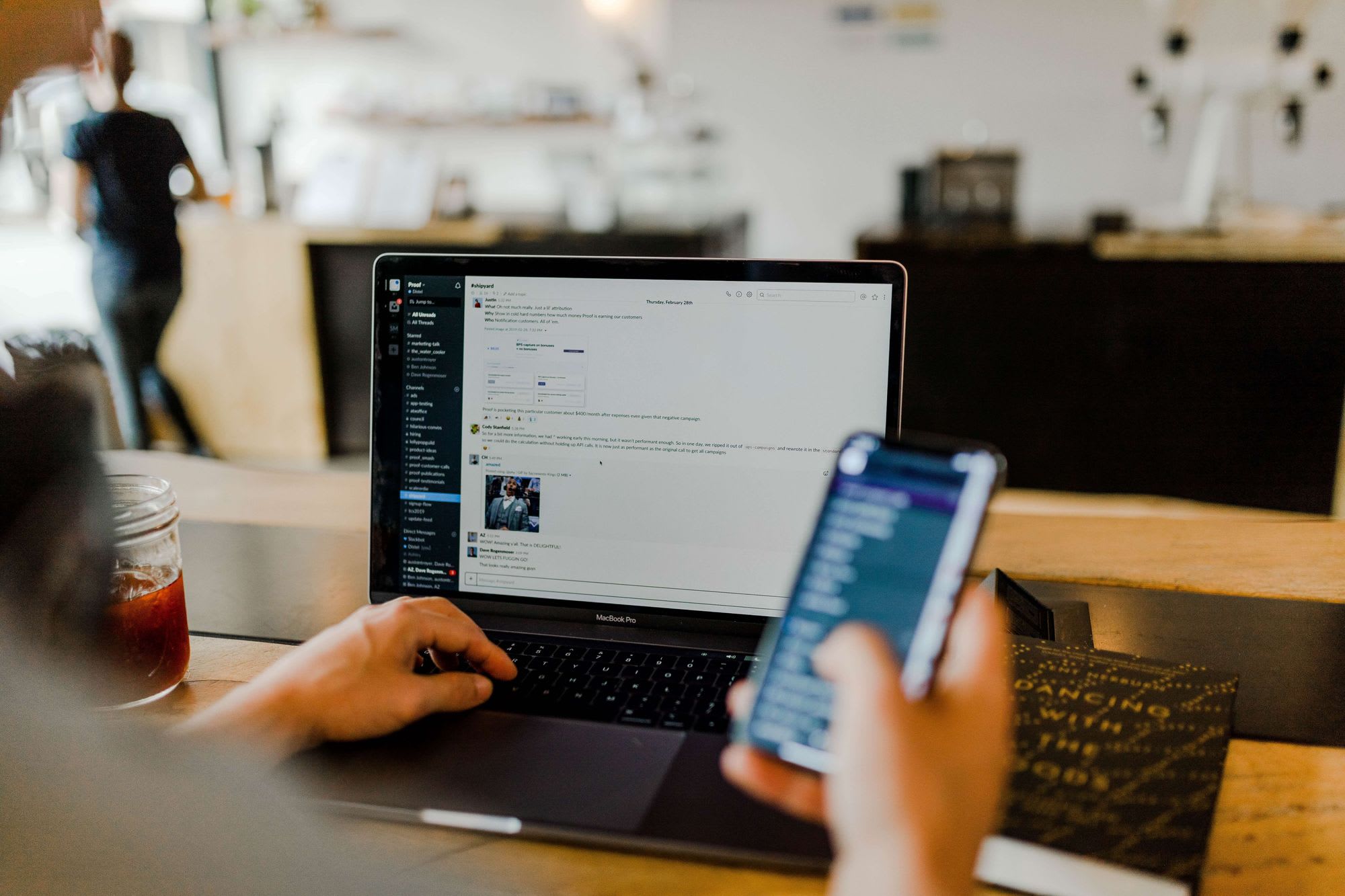 man with phone and laptop on slack