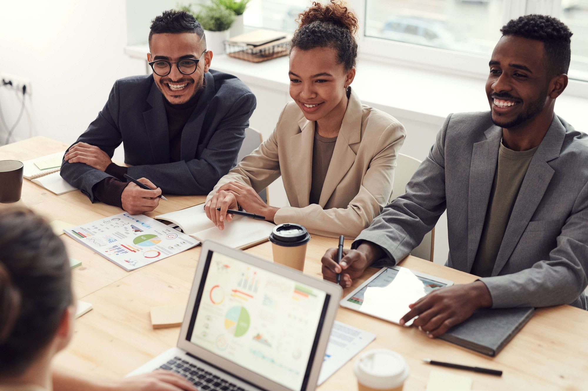 three employees on a table smiling