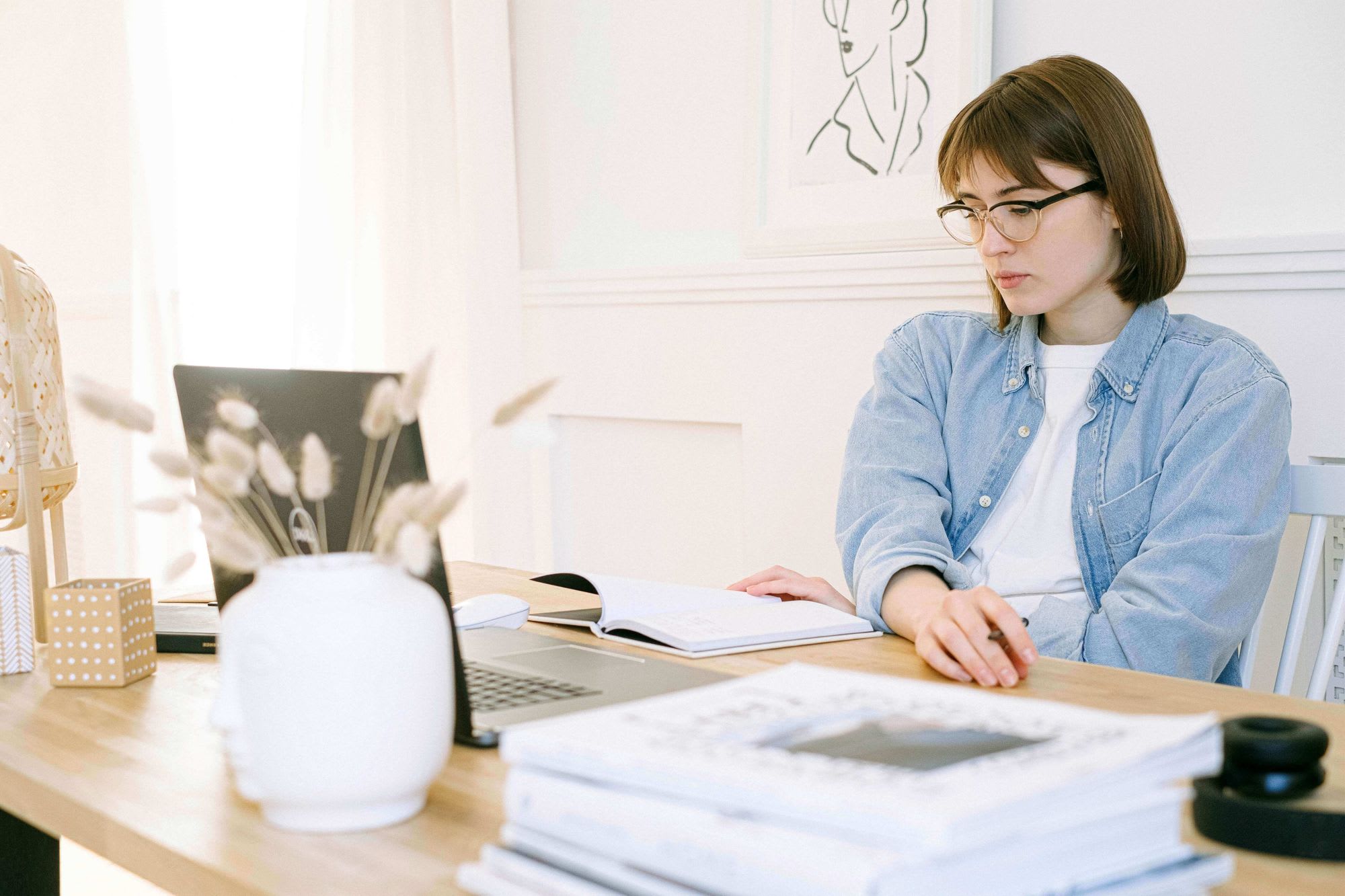 Women working on a table with notebook and laptop